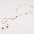 Detail of adjustable gold snake chain featuring a sliding buckle and two metal ball pendants - Bead Pendant