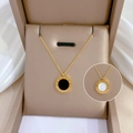 Goldene Halskette mit römischen Ziffern und doppelseitigen Anhängern in einer Schmuckschatulle - Gold