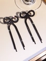 Sparkling black rhinestone bowknot earrings with long tassel drapes on soft background - Stud Earrings / Black