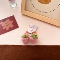Detailed view of pink plaid fabric strawberry hair ties with green leaves on card - Pink