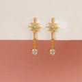 Detailed view of gold starburst earrings with clear zircon stones on a pedestal - Eight-pointed Star Zirconia Drop Studs