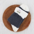 Morbide calze a righe in ciniglia grigio scuro e bianco su un vassoio intrecciato - Grigio scuro