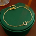 Bracciale in oro con ciondolo a ferro di cavallo in zirconi su portagioie verde - Oro