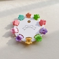 Macro view of 10-piece mini flower hair claws in colorful macaron shades on card display - Round Flower