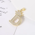 Collana con pendente lettera D a corona placcata oro e zirconi su sfondo bianco pulito - Lettera D