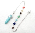 Gedetailleerd beeld van turquoise kristallen pendel met zeven gekleurde chakra-kralen - B24-Synthetisch Turkoois