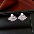 Detalle de pendientes en forma de abanico con perla blanca y circón en cuero negro - Plateado