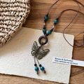 Détail d'un collier bohème avec pendentif papillon en bronze, anneau bois et perles - Papillon Rond Marron