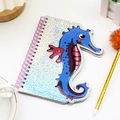 Macro view of spiral notebook featuring a 3D blue seahorse with silver glitter finish - Seahorse