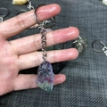 Handheld view of natural purple and green fluorite crystal keychain with silver clasp - Fluorite