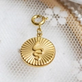 Vintage gold stainless steel sunburst pendant featuring an embossed snake design motif - Snake & Sunburst Medallion