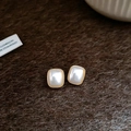 Close-up of square pearl earrings with gold frames on brown plush fabric background - Silver Needle Gold Square Style (HE23496)