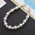 Detail of white gradient pearl phone chain with gold metal clasps on a black surface - Mixed Size Beaded Hand Chain (K146)