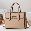 Beige textured leather tote bag with gold hardware and top handles shown in a lifestyle set - Khaki