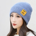 Light blue knitted beanie with a yellow label featuring MOMENT OF AMBITIONS text - Light Blue