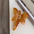 Detailed close-up of a marble texture amber acetate butterfly hair claw clip with engraving - Butterfly Claw / Caramel color