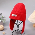 Winter red knitted earflap hat for women featuring a stylish brand label patch - Red