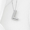 Detail macro of silver 3D bubble letter L pendant with high-polished mirror finish surface - Letter L Pendant