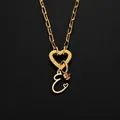 Elegant gold stainless steel necklace with heart clasp and crystal initial E pendant. - Letter E