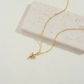 Elegante gouden kruis ketting met gekleurde zirkonia stenen op een stenen decoratie - Kleurrijk Zirkonia Kruis