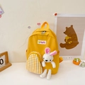 Vibrant yellow kids backpack with cartoon smiley patch and cute bunny plush accessory - Yellow