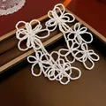 Eleganti orecchini a perno con fiori bianchi e nappe pendenti dal design a tre fiori - Bianco