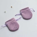 Close-up of purple velvet drawstring jewelry pouches with ribbon ties and F.D print - 7x8.5cm / Violet