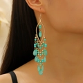 Detail shot of bohemian long tassel earrings with turquoise beads and gold-tone geometric frames - KC Gold 12243