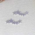 Ciondoli a forma di stella in acciaio inossidabile lucido su sfondo di tessuto bianco - Argento