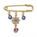 Gold palm safety pin brooch featuring blue evil eye charms and a sparkling crystal helm - Pin with Rhinestone Rudder, Blue Eye, and Crystal