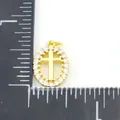 Oval gold cross pendant featuring a halo of white cubic zirconia with measuring scale - Cross