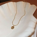 Detailed close-up of golden necklace with circular pendant inside a white shell dish - 4# Polished Round Disc Gold Fine Chain Necklace
