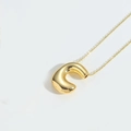 Macro shot of polished gold balloon-style letter pendant on a sleek metal necklace - Letter C