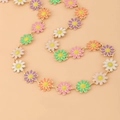 Detailed macro view of colorful daisy enamel charms on a dainty golden link chain necklace - Anklet / Colorful