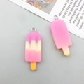 Close-up of pink and yellow gradient resin ice cream charms with metal loops for DIY jewelry - Purple