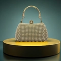 Detail einer Luxus-Perlen-Abendtasche mit goldenem Metallgriff und großem Perlenverschluss - Gold