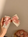 Pink satin bow hair clip with heart rhinestone detail held in hand for hair styling - Pink Rhinestone Heart Bow Hair Clip 1PC