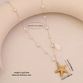 Gold stainless steel pearl necklace with starfish and shell pendants on a display stand - Starfish