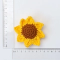 Handmade knitted sunflower charm in yellow and brown yarn with measurement ruler - 4-Ring Sunflower Ornament