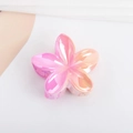 Detail of flower hair claw clip featuring iridescent pink gradient finish and marble texture - Plated Pink Orange