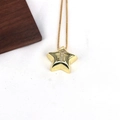 Detailed macro view of a gold star pendant with letter T inlay and clear zircons - Letter T