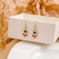 Close-up of spooky eyeball lollipop earrings with orange bows on a white gift box - Eyeball