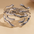 Macrodetail van de zilveren metalen armband in lavastijl met scharniermechanisme - Onregelmatige Koraaltak Armband / Zilver