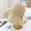Detail of beige straw hat with wavy brim and red cherry bow on a gold display stand - Beige with Yellow Ribbon