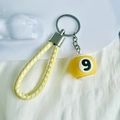Detail of yellow number 9 billiard ball keychain with yellow braided leather cord strap - No.9 (Yellow)