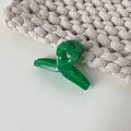 Detalle de una mini pinza para el cabello verde vibrante con diseño cruzado sobre punto - Verde