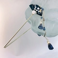 Detail of elegant Chinese hair pin featuring a black fan with white magnolia and blue tassels - Blue Fan Embroidery