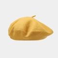 Detailed texture of a bright yellow wool beret hat shown against a clean background - Yellow