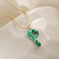 Dettaglio di un ciondolo a bambù verde su catena dorata posto su un vassoio di ceramica - Lettera P