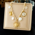 Golden woven cord necklace with sun, turtle and moon pendants displayed on a jewelry box - Sun Face Turtle Pearl Pendant Style (N3677)